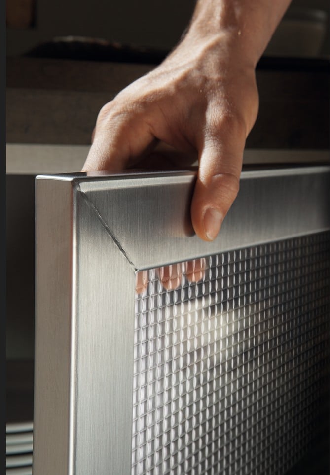 Käsi pitää metallista kehystä.