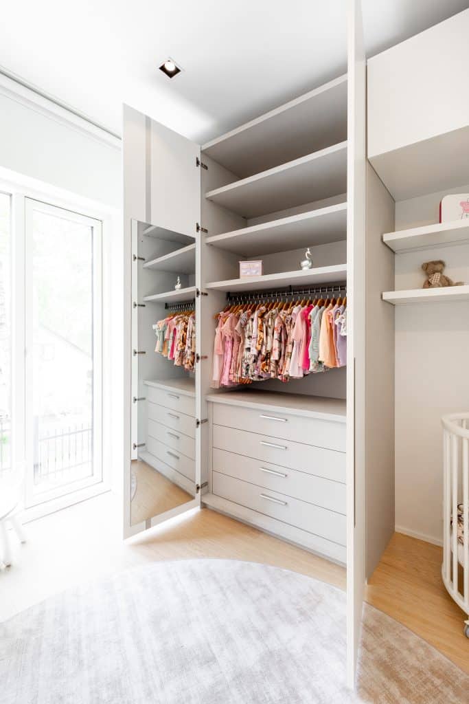 Tyylikäs vaatekaappi vaaleissa sävyissä.